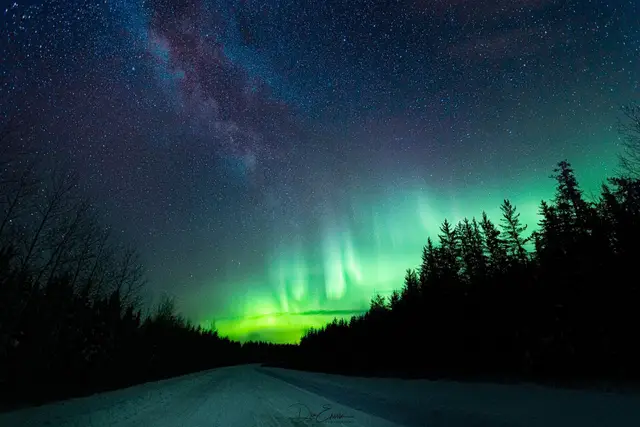 Northern lights over a snowy road